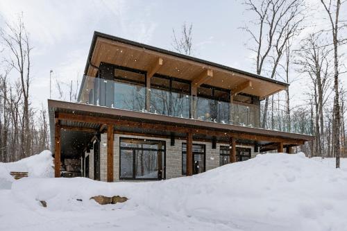 a house in the woods in the snow at Chalet Berg-Haus by Rendez-Vous Mont-Tremblant in La Conception