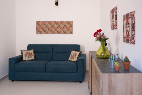 a living room with a blue couch and a table at Casa Zia Lina in Modica