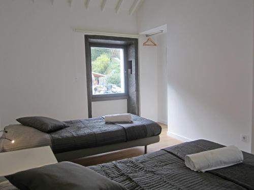 two beds in a room with a window at Furnas Valley in Furnas