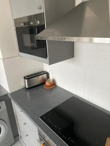 - une cuisine avec un comptoir noir et une cuisinière dans l'établissement Franca View Defense, à Puteaux