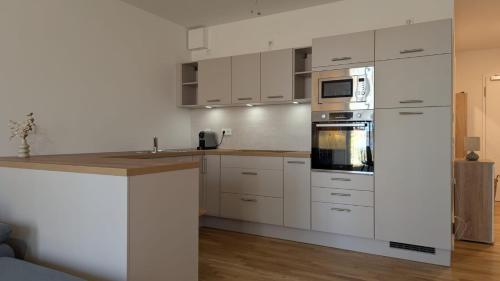 a kitchen with white cabinets and a stove top oven at Neue moderne große Wohnung am See mit Terrasse, Garten, Einbauküche, Badewanne, Dusche, nähe Berlin in Bestensee