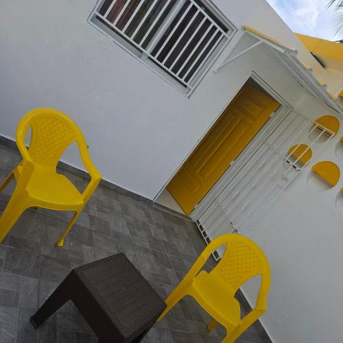 two yellow chairs sitting in front of a house at Villa del sol in Infiernito