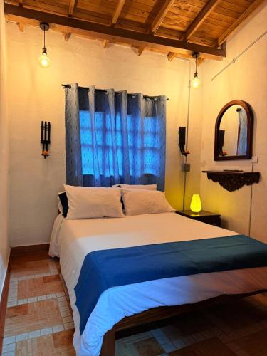 a bedroom with a large bed with a blue window at Cabaña ideal 5-9 personas cocina, wifi, cerca al parque y campestre in Jardin