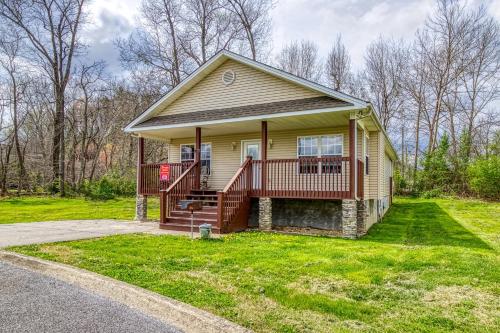 a small yellow house with a porch and a yard at Lee's Creekside in Pigeon Forge