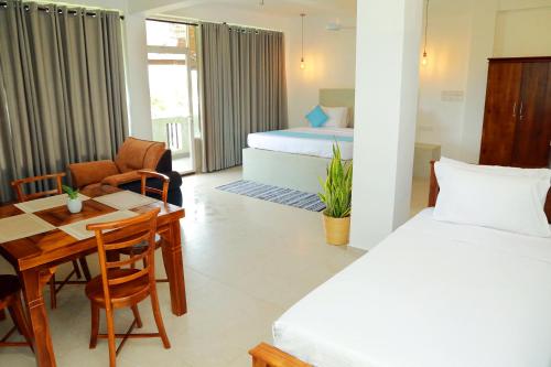 a hotel room with a bed and a table and a bedroom at Cocos in Midigama