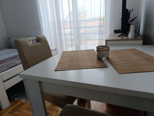 a white table with two mats on top of it at Nikola NS in Novi Sad