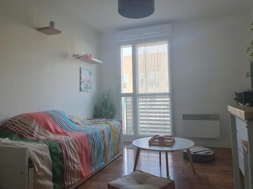 ein Wohnzimmer mit Sofa und Tisch in der Unterkunft L'îlot du Val d'Europe à 2 minutes du RER et à 5 minutes de Disneyland in Montévrain