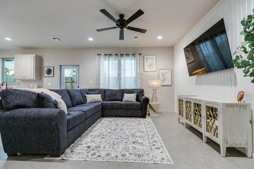 a living room with a blue couch and a ceiling fan at Holiday Haven with 3 BR and 2 BA New in San Angelo