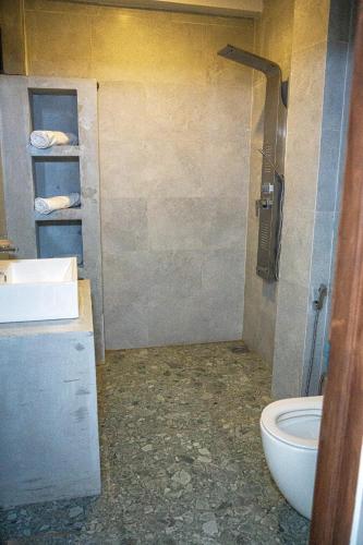 a bathroom with a toilet and a sink at Cocos in Midigama