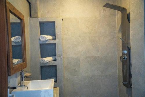 a bathroom with a sink and a shower with towels at Cocos in Midigama
