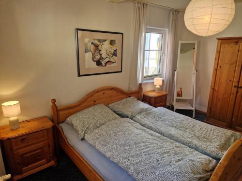 a bedroom with a bed and two lamps and a window at Ruhige Ferienwohnung mit Privatparkplatz in Sagard