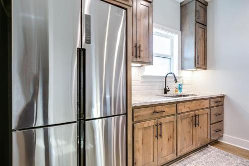 Una cocina con refrigerador de acero inoxidable y gabinetes de madera. en Brand New 3 BR 2 and a half BA, en San Angelo