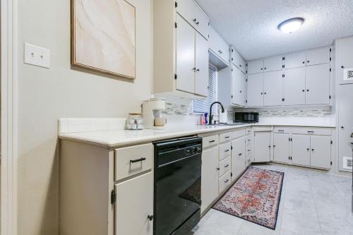 a kitchen with white cabinets and a black dishwasher at 4 BR with 3 BA Turf Backyard New in San Angelo