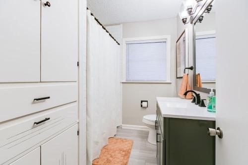 a bathroom with a sink and a toilet and a window at 4 BR with 3 BA Turf Backyard New in San Angelo