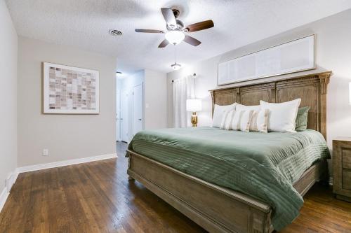 a bedroom with a large bed with a ceiling fan at 4 BR with 3 BA Turf Backyard New in San Angelo