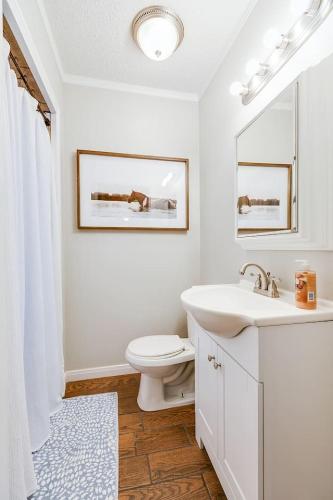 a white bathroom with a sink and a toilet at 4 BR with 3 BA Turf Backyard New in San Angelo