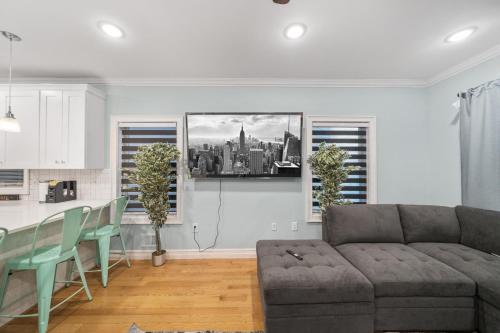 a living room with a couch and a kitchen at Skyline Haven Luxe NYC Escape in Jersey City