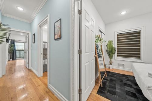 a hallway with white walls and a door with a mirror at Skyline Haven Luxe NYC Escape in Jersey City