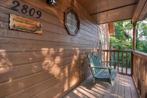 a blue chair sitting on the porch of a cabin at Forest Hollow in Pigeon Forge