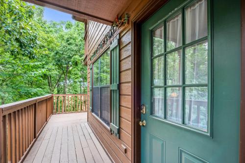 a front porch of a house with a green door at Forest Hollow in Pigeon Forge