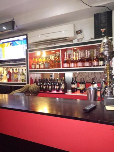 a bar with a red counter and a shelf of alcohol at Pulville Boulevard Hotel in Suru Lere