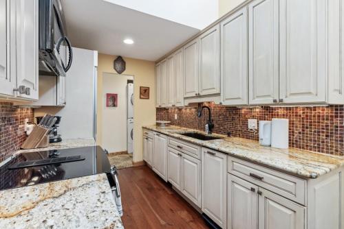 a kitchen with white cabinets and marble counter tops at Perfectly Located Beaver Creek Vacation Home in Avon