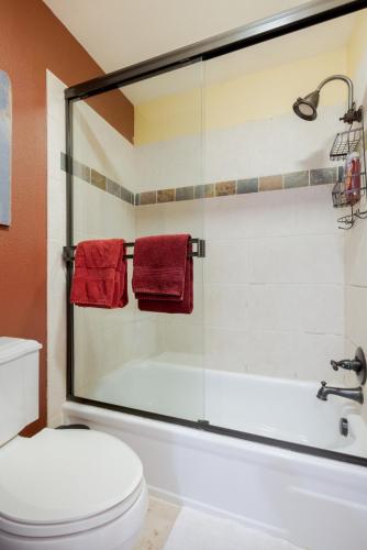 a bathroom with a tub and a toilet and red towels at Perfectly Located Beaver Creek Vacation Home in Avon