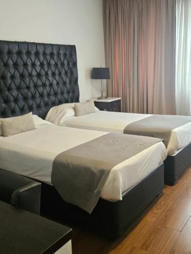 a hotel room with two beds and a headboard at Be Hollywood! in Buenos Aires