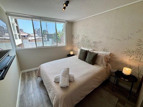 a bedroom with a large bed with a window at Encantador e Iluminado Departamento, Ñuñoa in Santiago