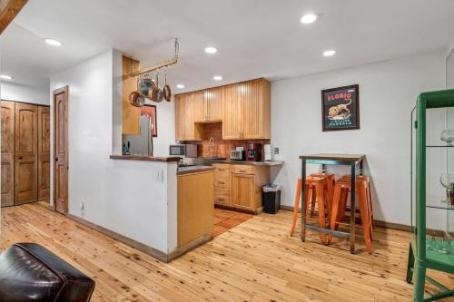 a kitchen with wooden cabinets and a wooden floor at Modern Mountain Riverfront Condo, Walk to Lift in Avon