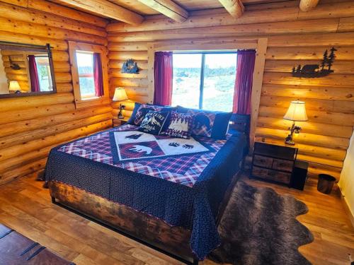 a bedroom with a bed in a log cabin at Stunning 2 Bedroom 1.5 Bath Cabin on 3.5 Acres in Bordenville