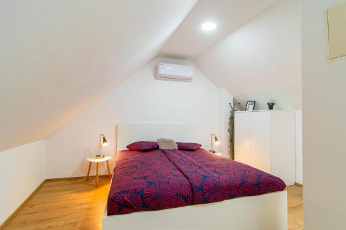 a bedroom with a bed with a red blanket at Flexible SelfCheckIns 71 - Zagreb - New - Center - 50m from the Main Square in Zagreb