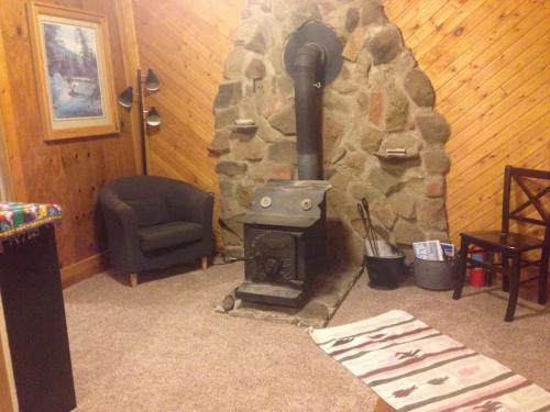 a wood stove in a room with a stone wall at Unique Historic Mountain Cabin In Beautiful Como in Como