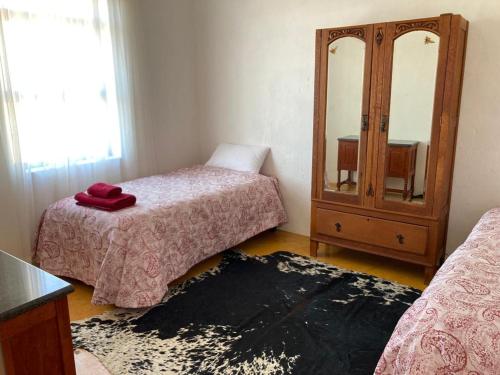 a bedroom with two beds and a dresser with a mirror at Kareepoort Guest Farm in Bloemfontein