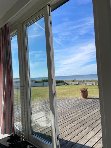 a sliding glass door with a view of the ocean at Havsnära studio in Höganäs