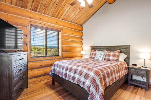 a bedroom with a bed and a television in a log cabin at Sweet MTN Cabin 2bedroom 2bath picturesque views in Como