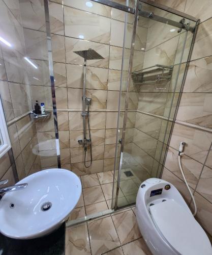 a bathroom with a shower and a toilet and a sink at BREAKING DAWN- TAEYANG Hotel Phú Quốc in Phu Quoc