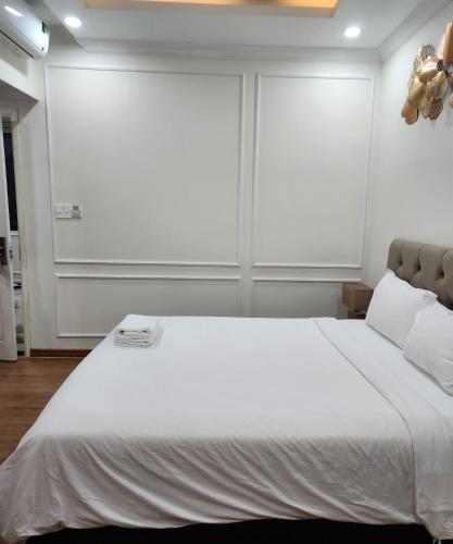 a bedroom with a large white bed with two windows at BREAKING DAWN- TAEYANG Hotel Phú Quốc in Phu Quoc