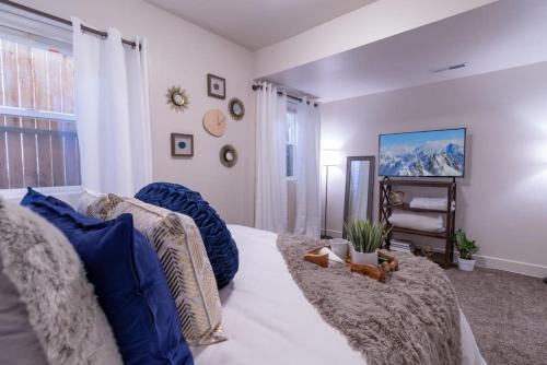 a bedroom with a bed with blue pillows at Cozy Relaxing Retreat Near Downtown SLC in Salt Lake City