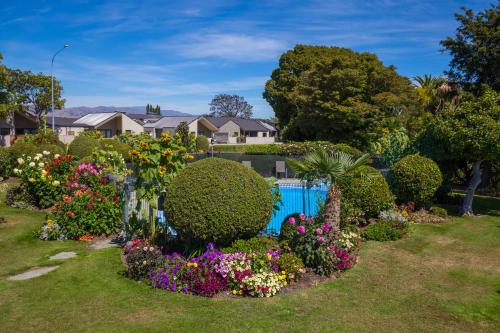a garden with colorful flowers and bushes at Middle Park Motel in Blenheim