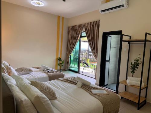 two beds in a hotel room with a balcony at Ipoh Lahat Mines Private Pool Lake Villa by IWH Suites in Lahat