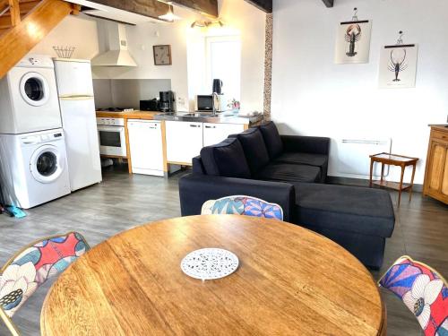 a living room with a table and a kitchen at Theven Plages in Santec