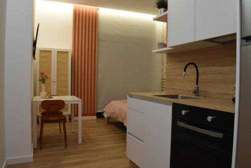 a small kitchen with a sink and a table at Apartamento Diseño Rosa in Ponteareas