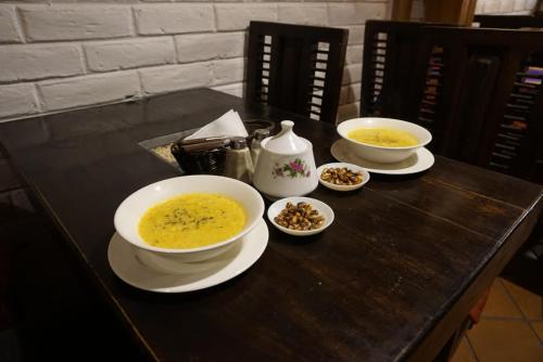 a table with three bowls of soup on it at Chuza Longa Home in Guamote