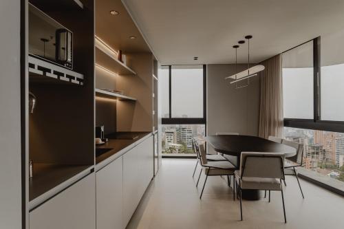 a kitchen and dining room with a table and chairs at Seissta Medellín in Medellín