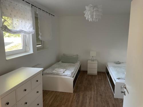 a white room with a bed and a window at Havelpension in Rathenow