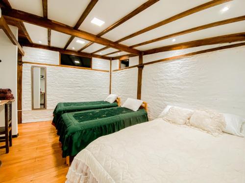a bedroom with two beds in a room at Chuza Longa Home in Guamote