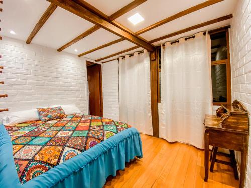 a bedroom with a bed and a table and a window at Chuza Longa Home in Guamote