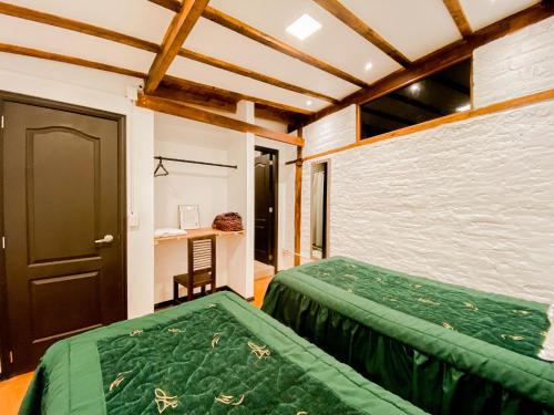 a bedroom with two beds and a desk in it at Chuza Longa Home in Guamote