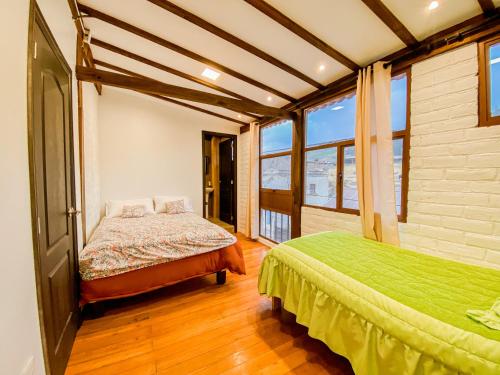 a bedroom with two beds and a large window at Chuza Longa Home in Guamote